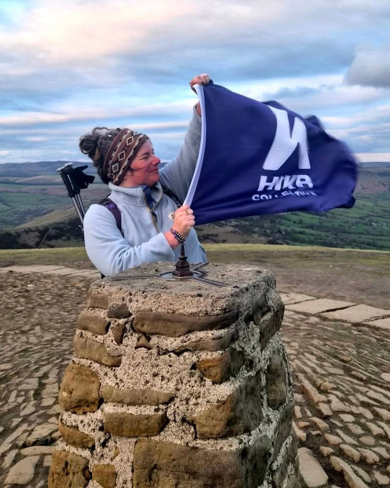 Person holding a flag on Mam Tor, Peak District National Park